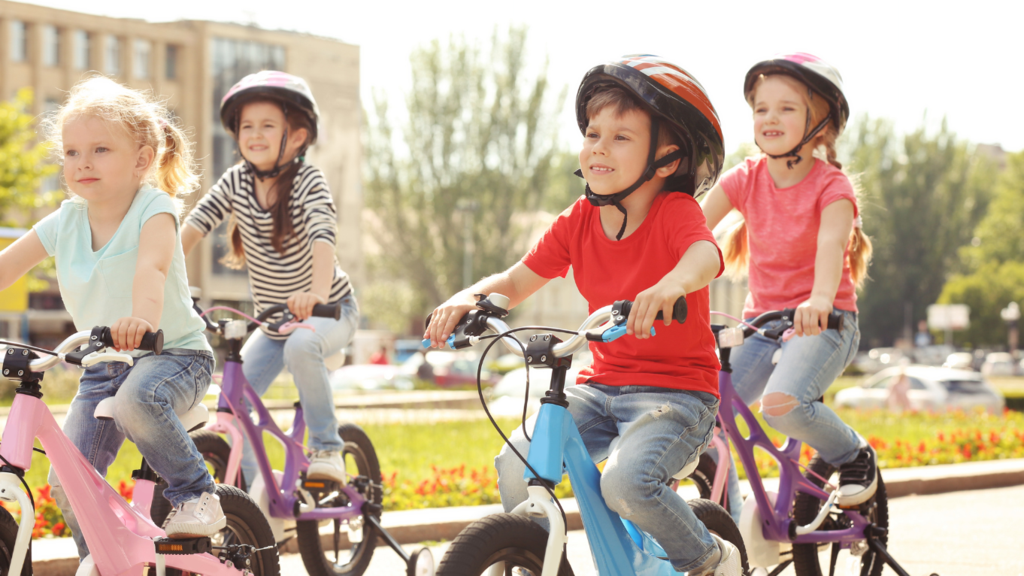 Vier Kinder auf dem Fahrrad Vier Kinder fahren auf ihren Fahrrädern durch eine Stadt